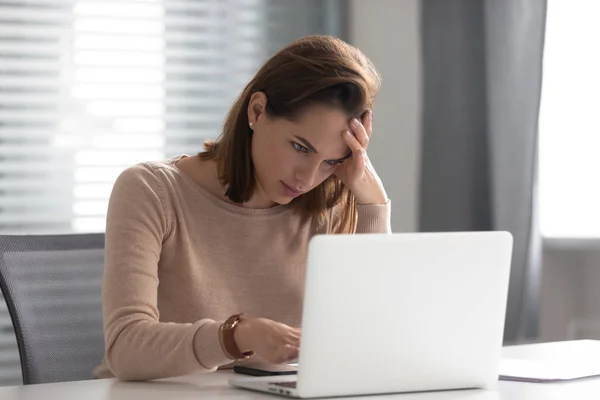 Напружена засмучена молода бізнес-леді використовує ноутбук, роблячи важке завдання — стокове фото