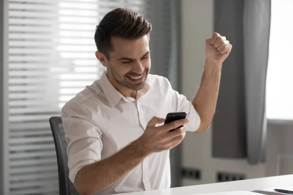 Encantado joven empresario ganador recibe gran nuevo en el mensaje móvil — Foto de Stock