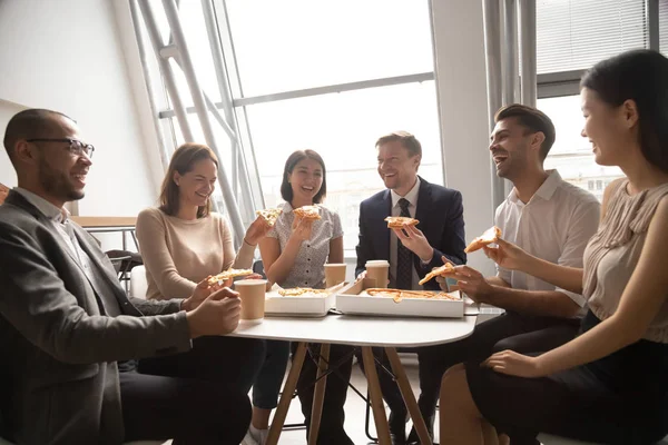 Equipo de negocios de trabajadores multiculturales felices que se divierten comiendo pizza — Foto de Stock