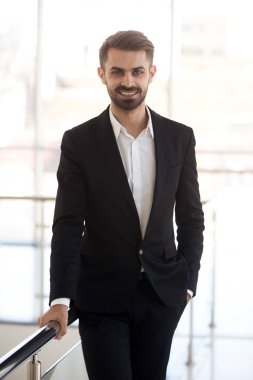 Ofis kamera bakarak gülümseyen işadamı dikey portre