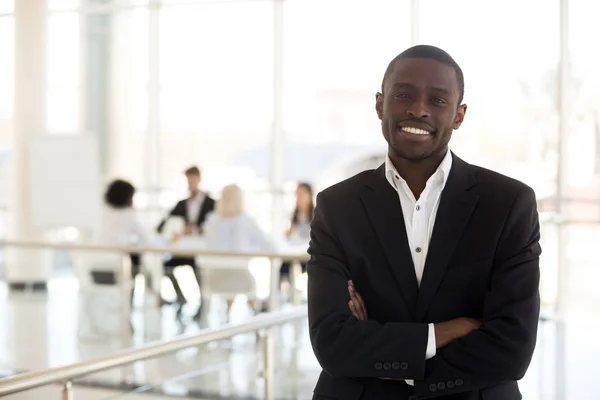 Retrato sorridente afro-americano empresário olhar para a câmera no corredor — Fotografia de Stock