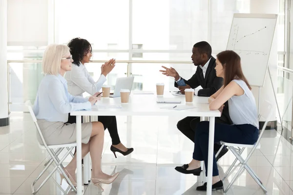 Diverse employees sit at table, discussing project in boardroom — Stock Photo, Image