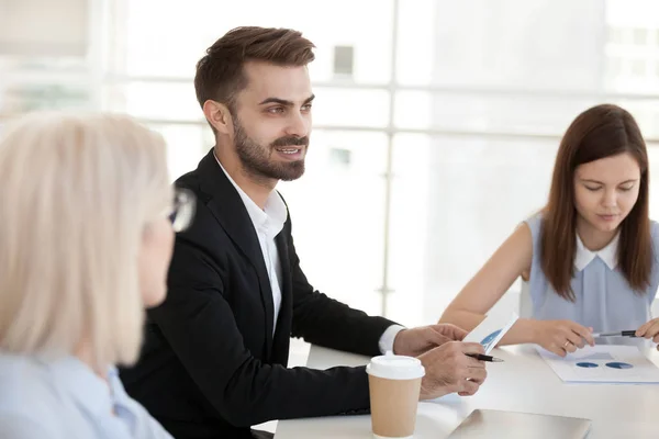 Zelfverzekerde zakenman zit aan tafel, bespreek project op bedrijfs meeting — Stockfoto