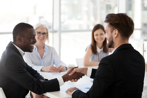 Smiling African American businessman shake hand of colleague at briefing — Stock Photo, Image