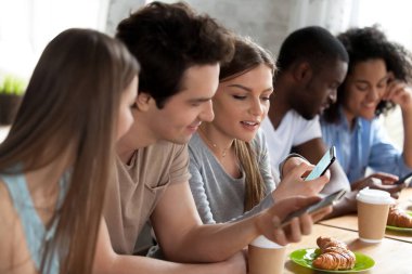 Kafede cep telefonları kullanarak karışık yarış mutlu arkadaşlar.