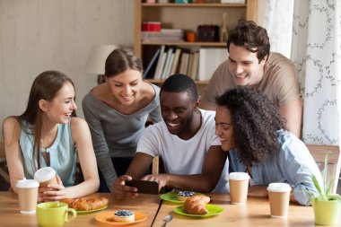 Akıllı telefonda komik videolar gösteren mutlu siyah adam.