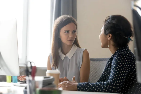 Young woman explain task, talk about new project with colleague