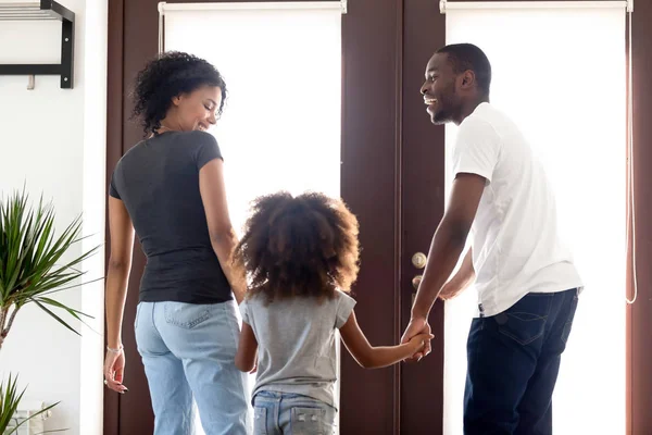 Rear view african family holding hands standing in the hallway — Stock Photo, Image