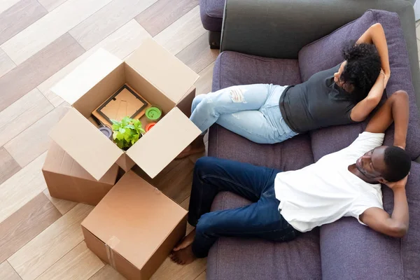 Above view african couple resting on couch on moving day — Stock Photo, Image