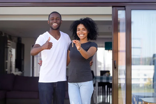 テラスに立つアフリカのカップルは、新しい家の鍵を保持します — ストック写真