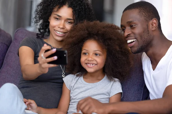 子供と陽気なアフリカの家族は、携帯電話を使用して自分撮り写真を撮ります — ストック写真