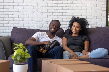 Evde köpek ile kanepede dinlenmek mutlu Afrikalı çift