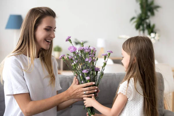 Cute przedszkola córka dając matka kwiaty — Zdjęcie stockowe
