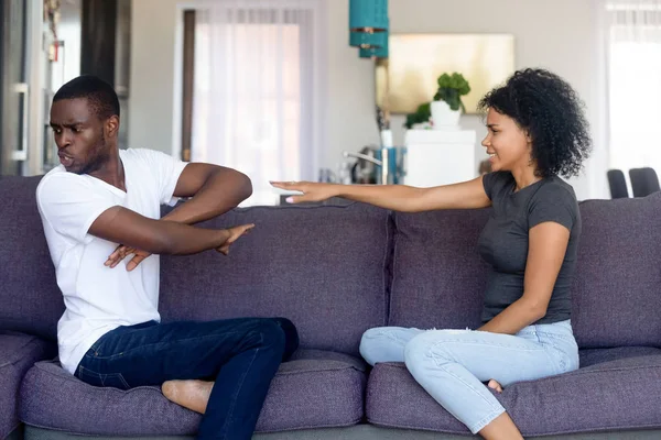 American angry couple sitting on couch quarrelling at home — Stock Photo, Image