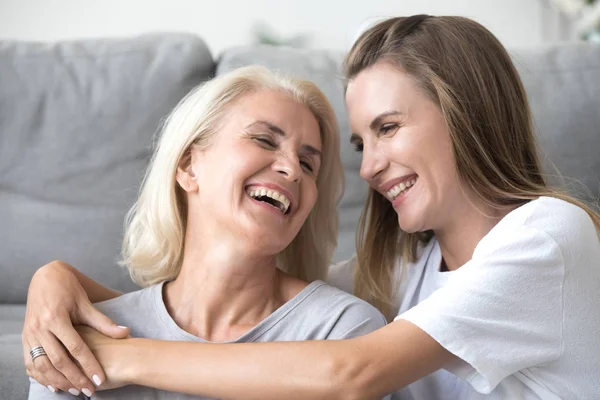 Мать и маленькая дочь смеются вместе, веселясь дома — стоковое фото