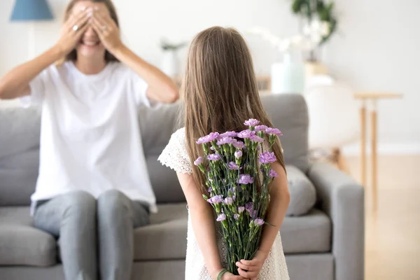 Fille préparée pour maman fleurs cachant derrière son dos — Photo