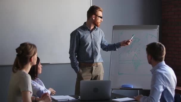 Redhead entrenador de negocios dando presentación al personal de la empresa utilizar flipchart — Vídeos de Stock