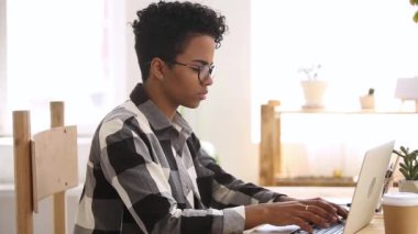 Kızgın Afrika etnik öğrenci kız yazarak bilgisayar ekranına bakıyor