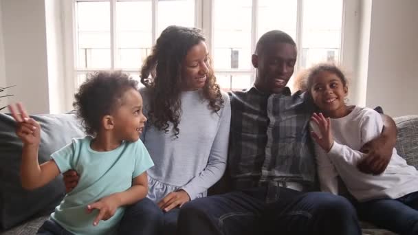 Famiglia africana seduta sul divano agitando le mani guardando la fotocamera — Video Stock