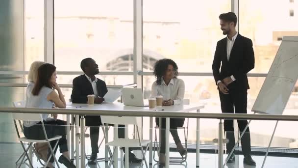 Geschäftsleute sitzen am Tisch und hören Businesscoach beim Training zu — Stockvideo