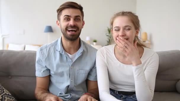 Überglückliches Paar sitzt auf Couch im Chat und schaut in Webkamera — Stockvideo