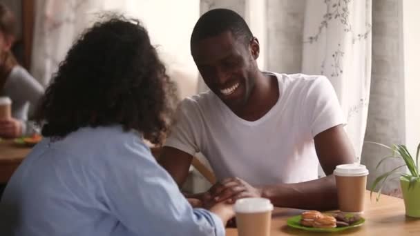 Afrikansk etnicitet par i kärlek sitter vid bordet i kaféet — Stockvideo
