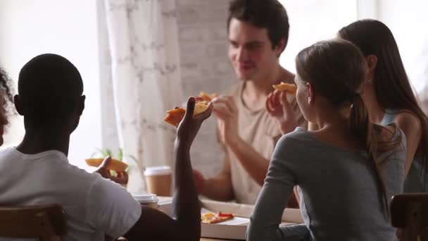 Διαφορετικοί φίλοι κουβέντα τρώγοντας πίτσα πίνοντας καφέ σε εσωτερικούς χώρους — Αρχείο Βίντεο