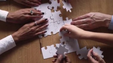 Bulmaca parçaları bağlayan çeşitli insanların çekim bakış elleri yukarıda