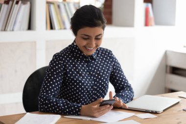 Gülümseyen hintli kız cep telefonu kullanarak eğitim dikkati dağıldı