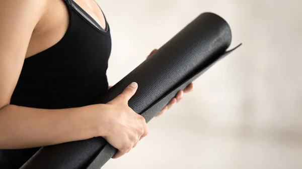 Closeup woman wear sportswear hold yoga mat ready for workout — Stock Photo, Image