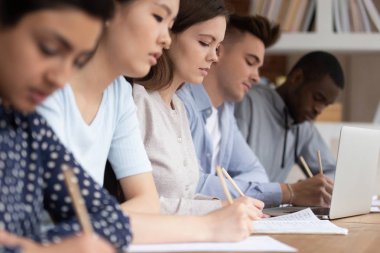 Çok kültürlü öğrenciler üniversite dersi sırasında not lar yapar