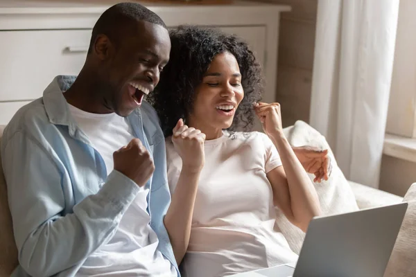 Los esposos africanos miran el portátil gritan con alegría celebran la victoria —  Fotos de Stock