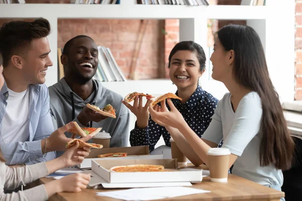 Diversos estudiantes se ríen de tener un descanso disfrutando de pizza — Foto de Stock