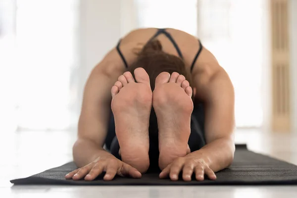 Woman doing Seated Forward Bend asana focus on barefoot foot — Stock Photo, Image