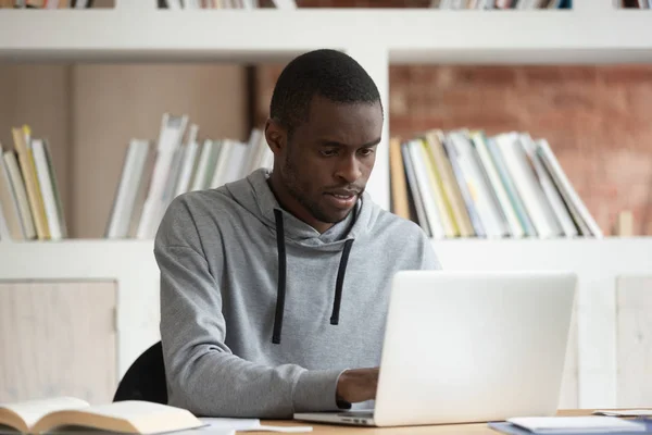 Estudiante negro serio estudiando con portátil en casa —  Fotos de Stock