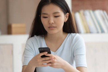 Asyalı kız akıllı telefon mesajlaşma veya mesajlaşma kullanarak tutun