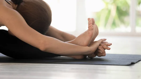 Femme pratiquant la pose de flexion avant assise sur tapis vue rapprochée — Photo