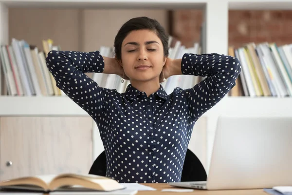 Vreedzame Indiase meisje ontspannen op werkplek met ogen gesloten — Stockfoto