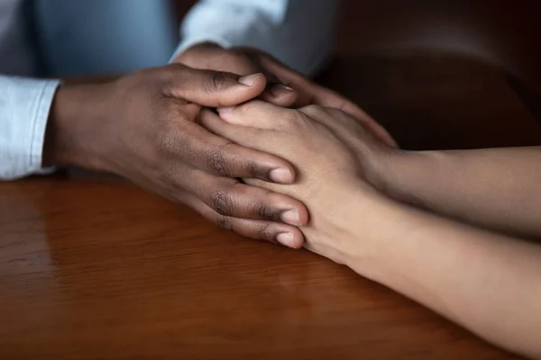 African guy holds hand of beloved girl close up image — Stock Photo, Image