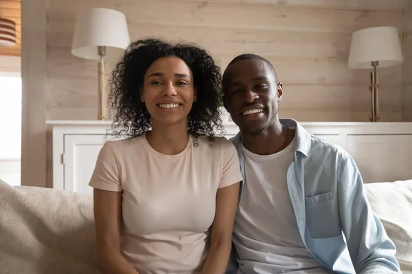 Smiling african couple sitting on couch making video call