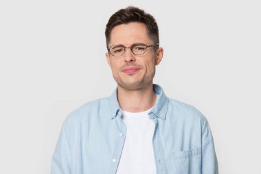 Headshot portre hoş olmayan kaşçlayan adam stüdyo arka plan üzerinde poz