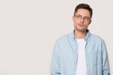 Gri beyaz stüdyo arka plan üzerinde duran gözlük şüpheli adam