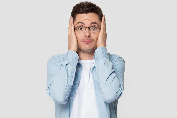 Worried guy holding head in hands pose on grey background — Stock Photo, Image