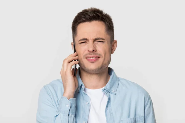 Headshot studio portrait annoyed dissatisfied guy talking on mobile phone — Stock Photo, Image