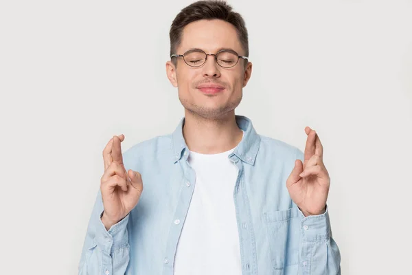 Jefe de estudio retrato tipo con los ojos cerrados cruzando los dedos —  Fotos de Stock