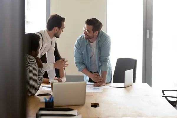 Smiling male workers discussing project at group meeting in office — Stock Photo, Image