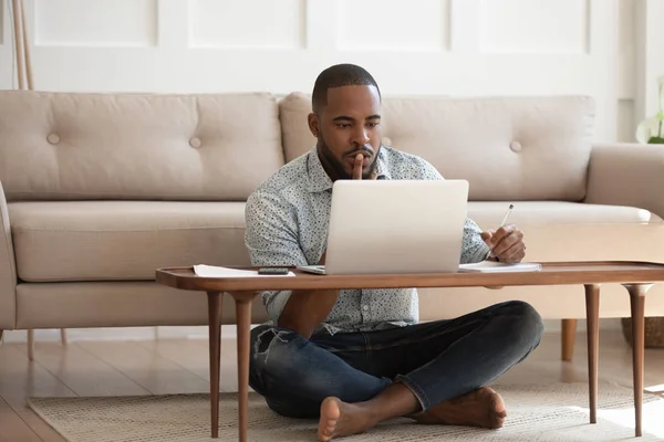 Homem africano focado estudando ou trabalhando em laptop em casa — Fotografia de Stock