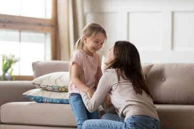 Anne ve kızı birbirlerine bakarak gülüyor mutlu hissediyor