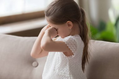 Üzgün küçük kız kanepede oturan ve ağlıyor
