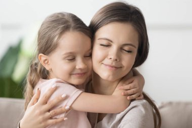 Yakın sevgi dolu anne sarılmak küçük sevimli kızı